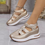 Gold sandals with white soles worn by a person on a light gray floor.