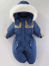 Children's dark blue one-piece winter snowsuit featuring a fluffy white faux fur-trimmed hood, rust-colored accents, elasticized waist, and front pockets.