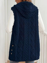 Woman wearing a dark blue hooded sherpa vest coat over a white long-sleeve top with blue jeans for a cozy fall and winter outfit.