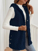 Woman wearing a dark blue hooded sherpa vest coat over a white long-sleeve top with blue jeans for a cozy fall and winter outfit.