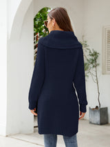 Woman wearing a dark blue turtleneck waffle-knit slit sweater dress with long sleeves and a relaxed fit for fall.
