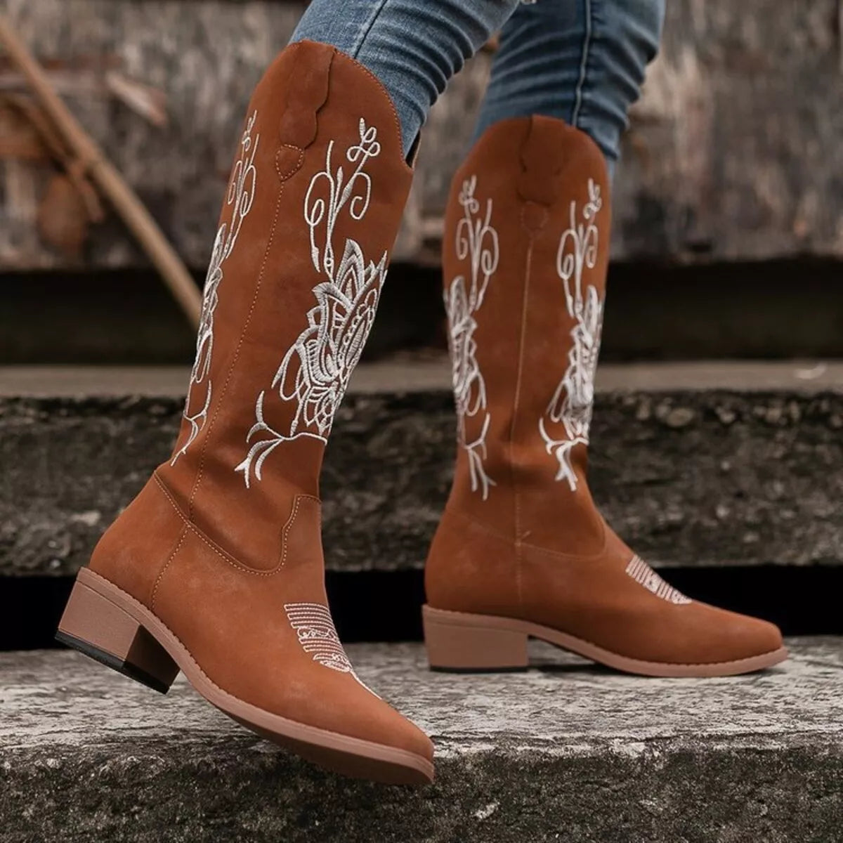 Women’s dark brown Western cowboy boots with white embroidered detailing and mid-height block heels.