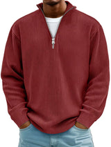 Man wearing a dark brown ribbed corduroy quarter zip pullover sweatshirt layered over a white shirt.