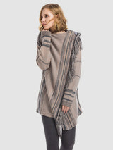 Woman wearing the Angel Wings tassel striped open-front cardigan in dark gray, featuring earthy multicolor stripes, a draped asymmetrical front, and long fringe trim.