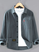 Men’s dark gray plus size button-up long sleeve shirt with multiple pockets, shown layered over a white T-shirt.
