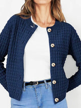 Women's button-up cable-knit cardigan in dark navy with long sleeves and textured knit, styled with denim for a classic fall outfit, available in sizes Small–2XL.
