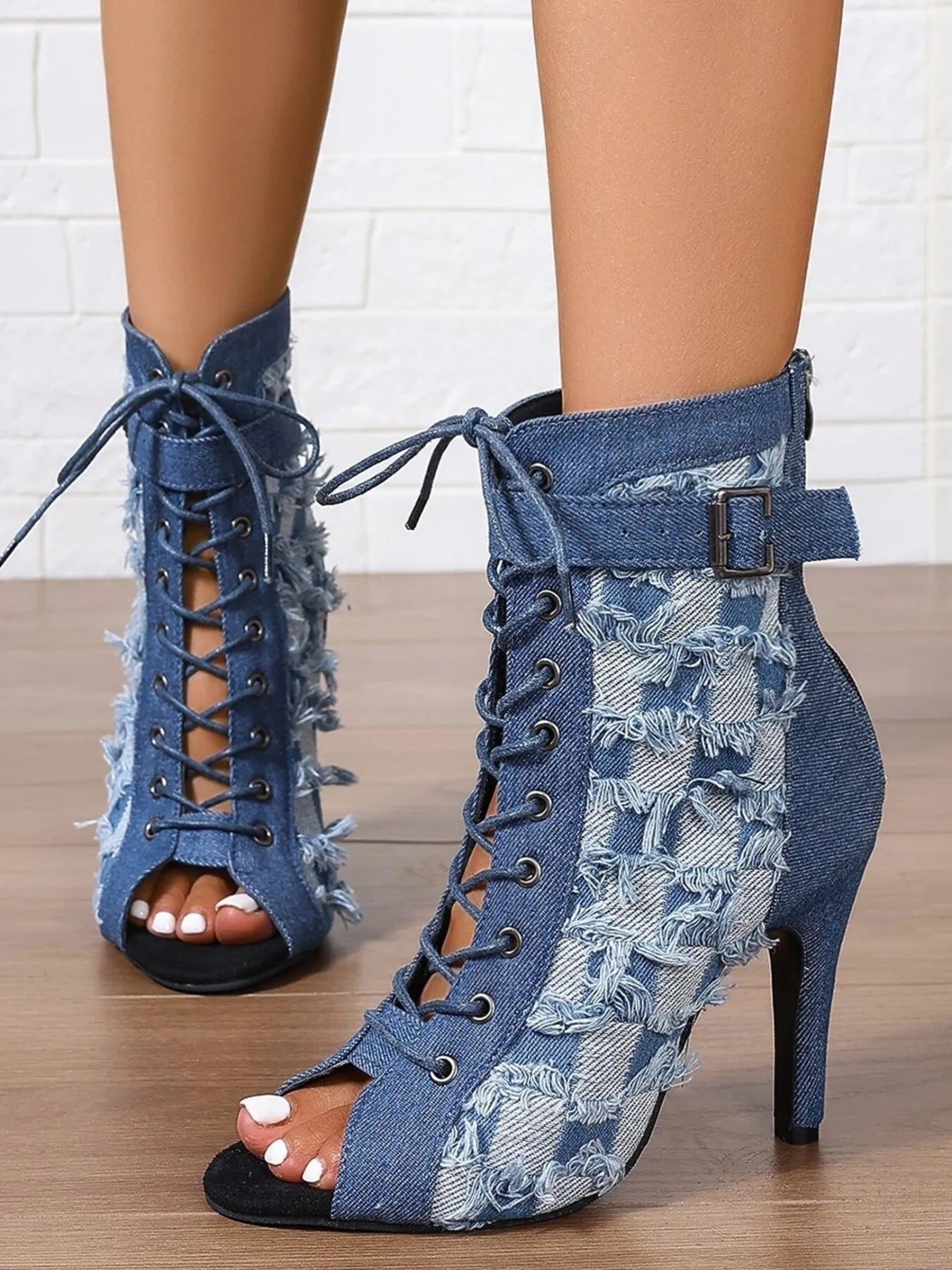 Blue denim lace-up high-heeled shoes on a wooden floor.