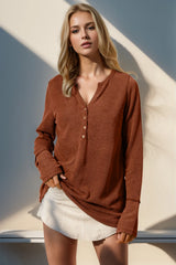 Woman wearing a brown ribbed sweater and white shorts against a neutral background
