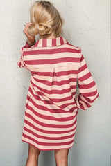 Person wearing a red and white striped dress against a textured white wall.