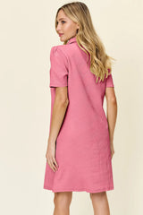 Woman wearing a pink dress with a subtle pattern on a beige background