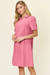 Woman wearing a pink dress with a collar on a beige background