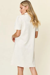 Woman wearing a white dress with a textured pattern on a beige background