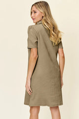 Woman wearing a khaki dress against a plain background