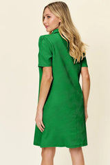 Woman wearing a green dress against a beige background