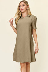 Woman wearing a khaki dress against a beige background