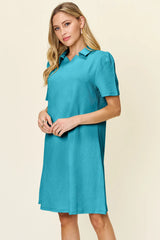 Woman wearing a pastel blue dress with a collar on a beige background