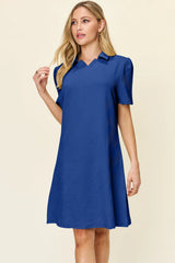 Woman wearing a royal blue dress against a beige background
