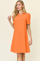 Woman wearing an orange dress against a beige background