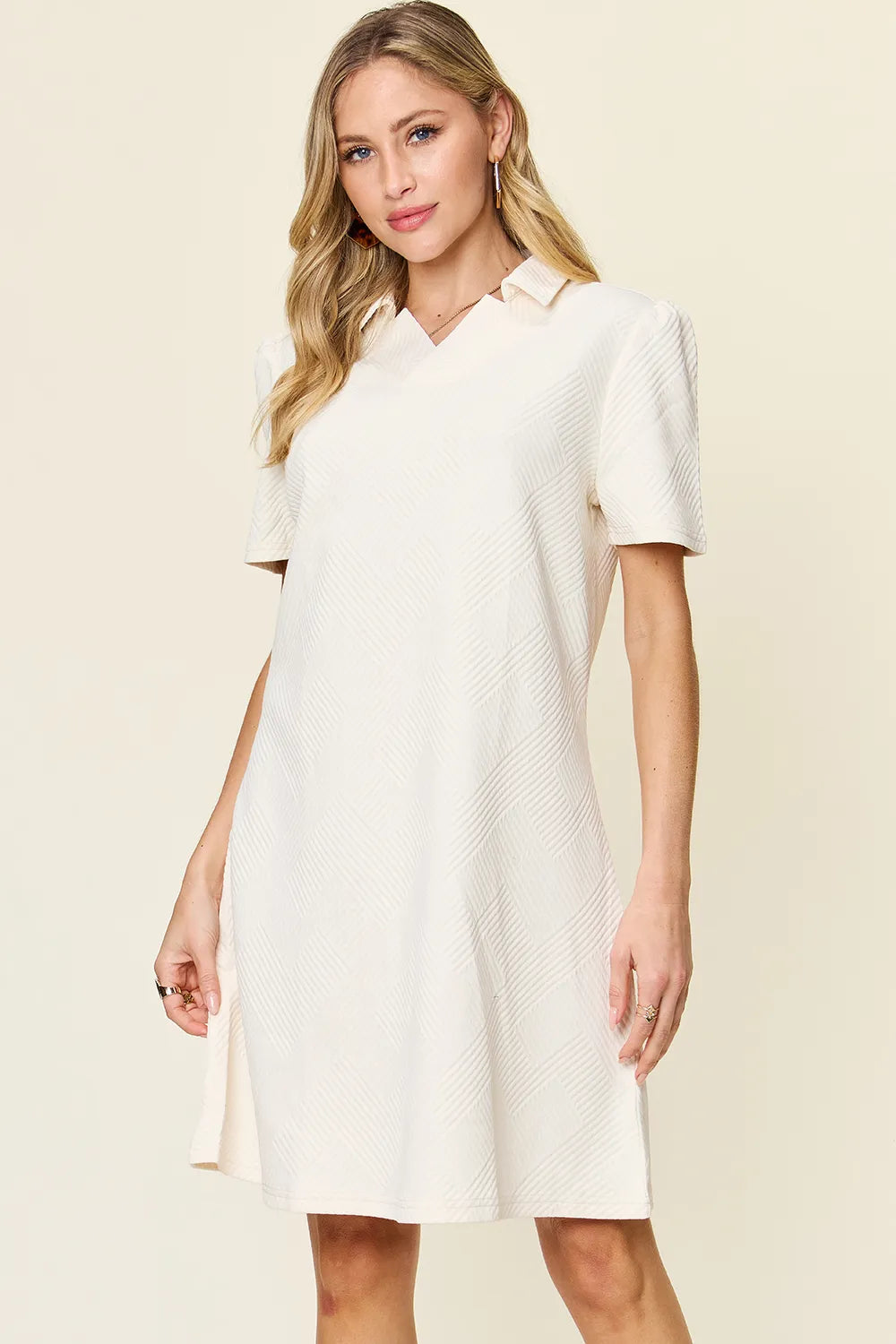 Woman wearing a white dress against a beige background