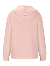 Woman wearing a blush pink textured drawstring quarter-button long sleeve hoodie paired with black jeans, perfect for casual fall outfits, available in 10 colors and sizes Small–2XL.