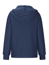 Woman wearing a dark blue textured drawstring quarter-button long sleeve hoodie paired with black jeans, perfect for casual fall outfits, available in 10 colors and sizes Small–2XL.