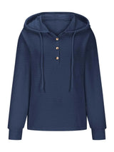 Woman wearing a dark blue textured drawstring quarter-button long sleeve hoodie paired with black jeans, perfect for casual fall outfits, available in 10 colors and sizes Small–2XL.
