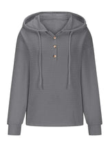 Woman wearing a gray textured drawstring quarter-button long sleeve hoodie paired with black jeans, perfect for casual fall outfits, available in 10 colors and sizes Small–2XL.