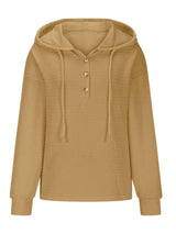 Woman wearing a mustard textured drawstring quarter-button long sleeve hoodie paired with black jeans, perfect for casual fall outfits, available in 10 colors and sizes Small–2XL.