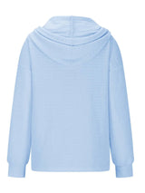 Woman wearing a pastel blue textured drawstring quarter-button long sleeve hoodie paired with black jeans, perfect for casual fall outfits, available in 10 colors and sizes Small–2XL.