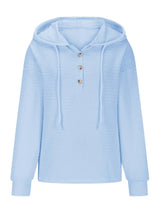 Woman wearing a pastel blue textured drawstring quarter-button long sleeve hoodie paired with black jeans, perfect for casual fall outfits, available in 10 colors and sizes Small–2XL.