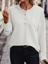 Woman wearing a white textured drawstring quarter-button long sleeve hoodie paired with black jeans, perfect for casual fall outfits, available in 10 colors and sizes Small–2XL.