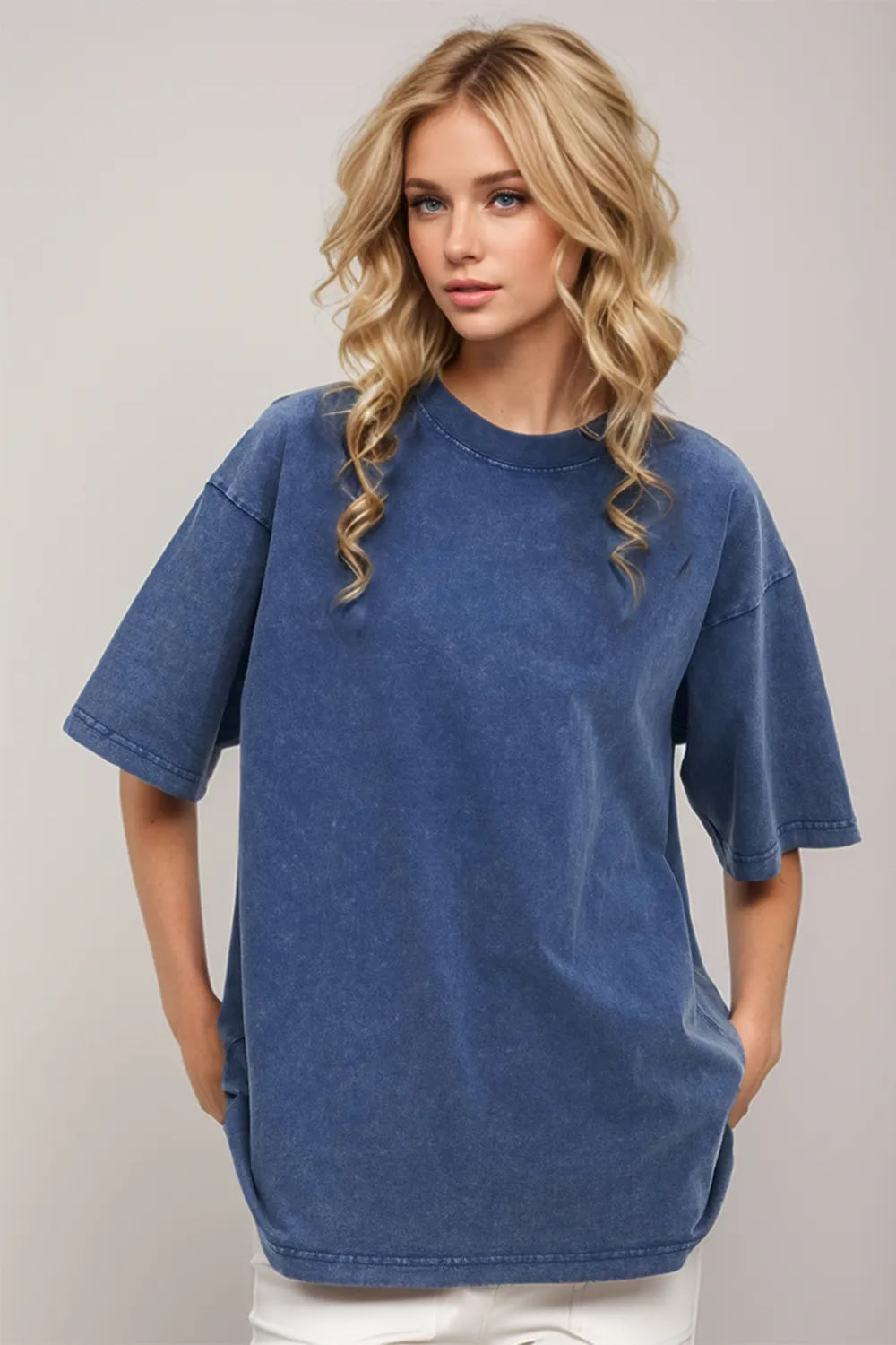 Woman wearing an oversized dusty blue Basic Bae round-neck half-sleeve T-shirt styled with dark denim jeans and a long pendant necklace for a relaxed, casual look.