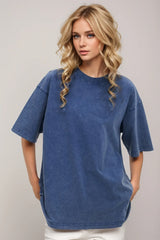 Woman wearing an oversized dusty blue Basic Bae round-neck half-sleeve T-shirt styled with dark denim jeans and a long pendant necklace for a relaxed, casual look.