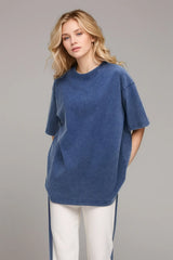 Woman wearing an oversized dusty blue Basic Bae round-neck half-sleeve T-shirt styled with dark denim jeans and a long pendant necklace for a relaxed, casual look.