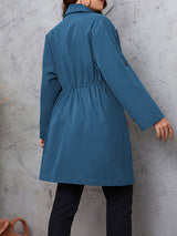 Woman wearing the Honey Plus Size Lapel Collar Drawstring Roll-Tab Sleeve Trench Coat in dusty blue with black denim and a black top, lightweight plus size fall trench coat from Chic Mystik Boutique.