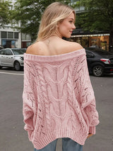 Woman wearing a dusty pink cable knit openwork off-shoulder sweater with distressed jeans and a wide-brim hat.
