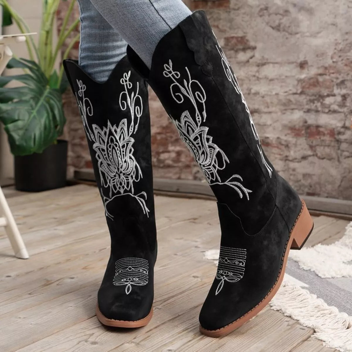 Women’s black Western cowboy boots with white embroidered detailing and mid-height block heels.