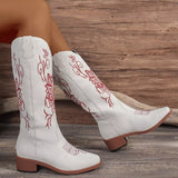 Women’s white Western cowboy boots with red embroidered detailing and mid-height block heels.