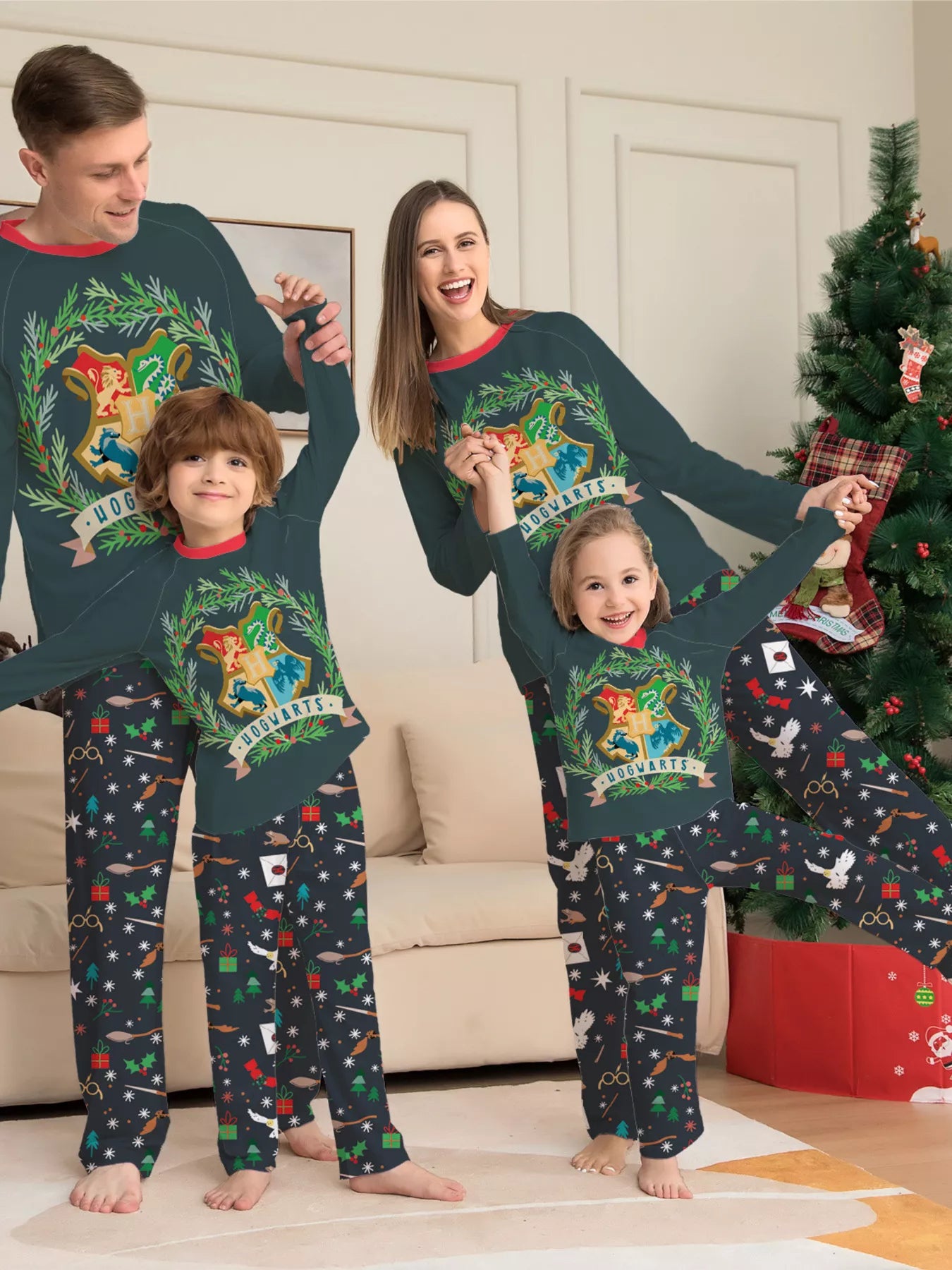 Family wearing matching dark green Hogwarts graphic Christmas pajama tops with coordinating navy holiday print pajama pants.