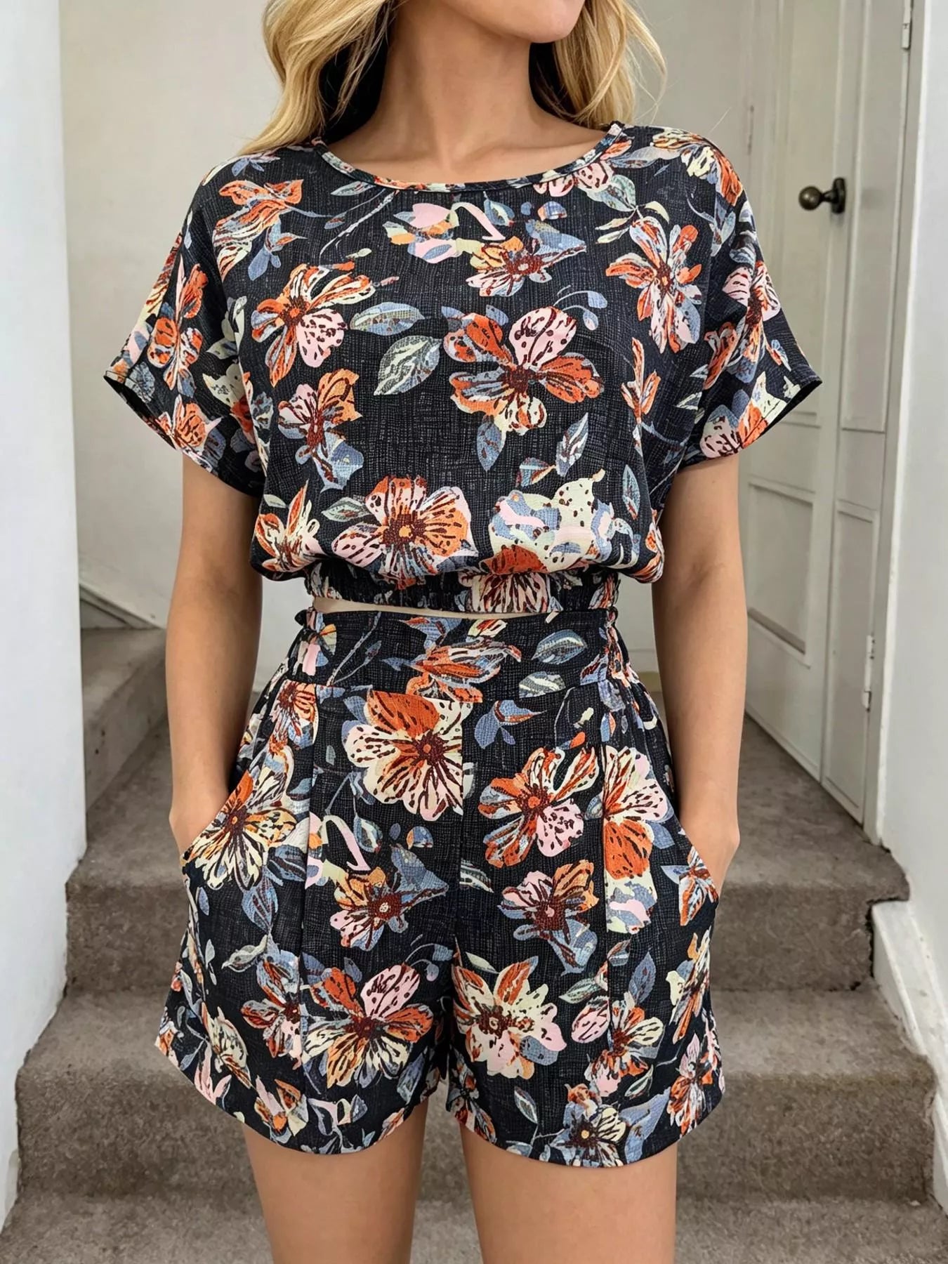 Person wearing a floral two-piece outfit standing on stairs.