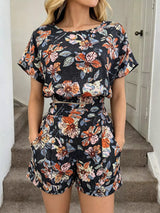 Person wearing a floral two-piece outfit standing on stairs.