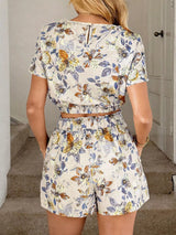 Woman wearing a floral two-piece outfit in Off White in a home setting