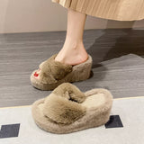 Brown fuzzy slippers worn indoors on a wooden floor.