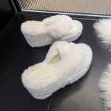 Pair of white fluffy slippers on a dark surface