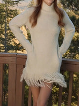 Woman wearing an apricot fringe turtleneck long sleeve sweater dress with brown knee-high boots, a cozy fall outfit from Chic Mystik Boutique.