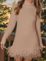 Woman wearing a khaki fringe turtleneck long sleeve sweater dress with brown knee-high boots, a cozy fall outfit from Chic Mystik Boutique.