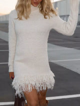 Woman wearing a white fringe turtleneck long sleeve sweater dress with brown knee-high boots, a cozy fall outfit from Chic Mystik Boutique.