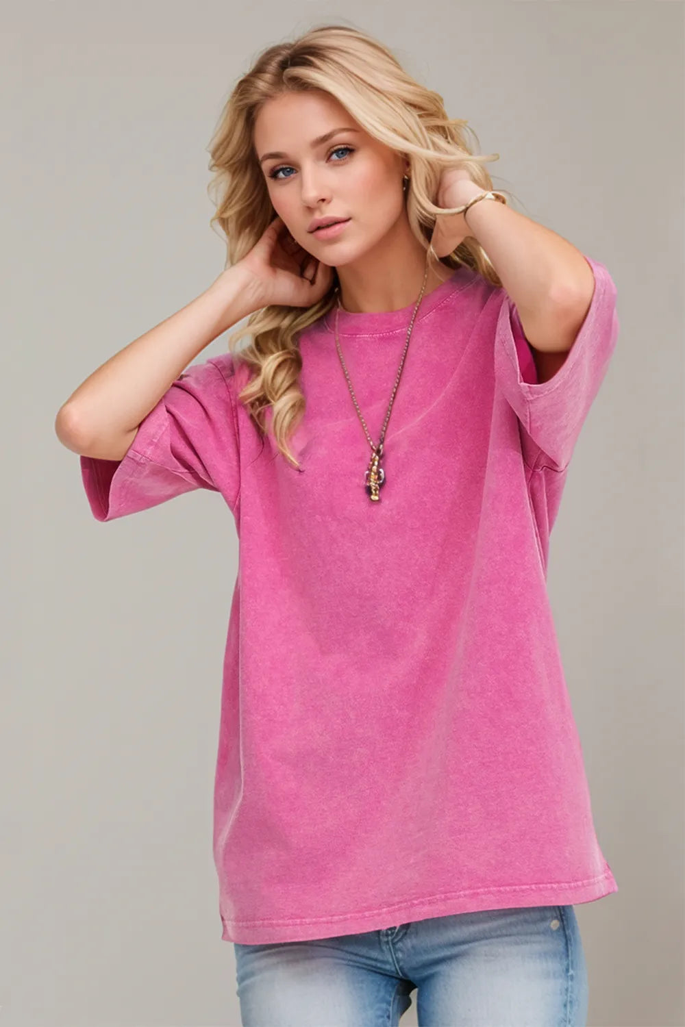 Woman wearing an oversized fuchsia Pink Basic Bae round-neck half-sleeve T-shirt styled with dark denim jeans and a long pendant necklace for a relaxed, casual look.