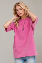 Woman wearing an oversized fuchsia Pink Basic Bae round-neck half-sleeve T-shirt styled with dark denim jeans and a long pendant necklace for a relaxed, casual look.