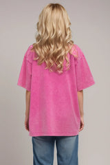 Woman wearing an oversized fuchsia Pink Basic Bae round-neck half-sleeve T-shirt styled with dark denim jeans and a long pendant necklace for a relaxed, casual look.